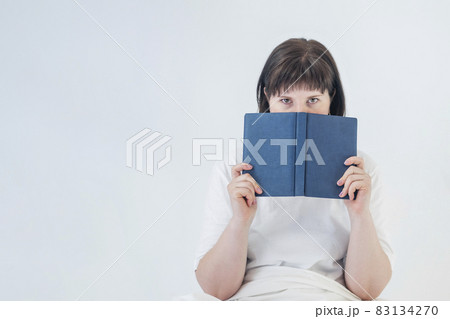 Portrait of young dark-haired woman with book in her hands on white background. Concept of education. Portrait of young dark-haired woman with book in her hands on white background. Concept of education. 83134270