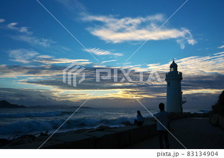 夕日の伊良湖岬灯台にて記念撮影するカップル 83134904
