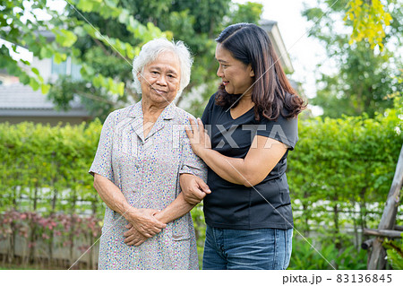 Asian elderly woman with caregiver daugther walking  with happy in nature park. 83136845