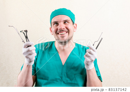 Funny doctor ENT, with instruments in his hands. 83137142