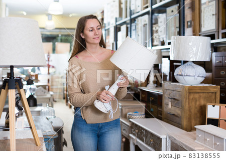 Woman looking for table lamp in shop 83138555