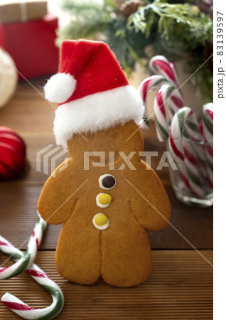 Gingerbread man cookie with Christmas red hat on rustic, wooden background with winter decorations 83139597