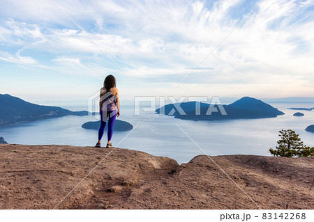 Adventurous Woman Hiking on top of Mountain Landscape 83142268