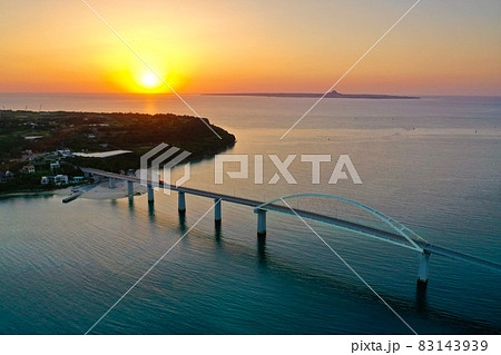 沖縄の海に沈む夕陽(瀬底島・瀬底大橋・伊江島) 83143939