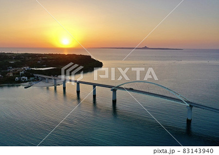 沖縄の海に沈む夕陽(瀬底島・瀬底大橋・伊江島) 83143940