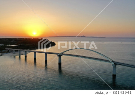 沖縄の海に沈む夕陽(瀬底島・瀬底大橋・伊江島) 83143941