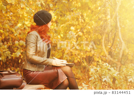 Autumn portrait of a red-haired woman. 83144451