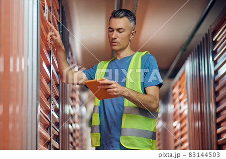 Attentive man with tablet checking data 83144503