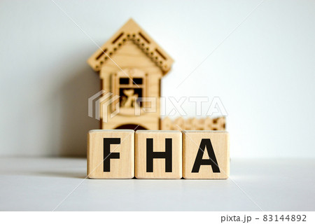 Wooden cubes form the word 'FHA, federal housing administration' near miniature house. Beautiful white background, copy space. business concept. Wooden cubes form the word 'FHA, federal housing administration' near miniature house. Beautiful white background, copy space. business concept. 83144892
