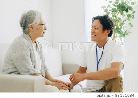 訪問介護する男性と高齢者(笑顔) 訪問介護する男性と高齢者(笑顔) 83151034