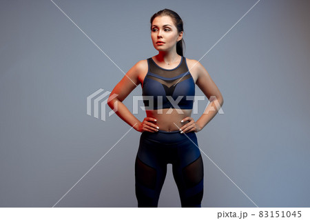 Healthy fit young woman in sportswear standing over a gray background Healthy fit young woman in sportswear standing over a gray background 83151045