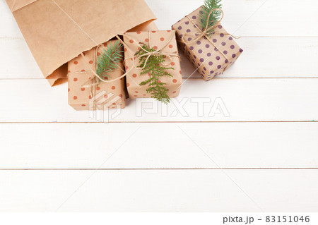 Gifts wrapped with craft paper on white wooden table 83151046