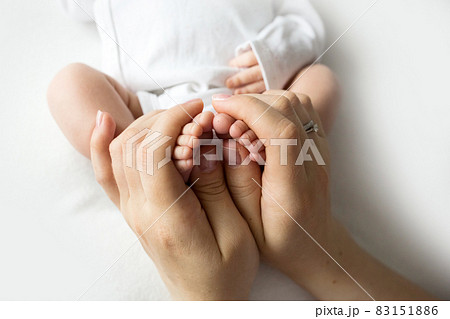 Hands of parents. The legs, feet of the newborn in the hands of mom and dad. Hands of parents. The legs, feet of the newborn in the hands of mom and dad. 83151886