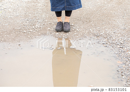 水たまりの前に立つ女性　水たまりと足元 83153101