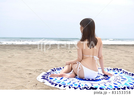 九十九里の海岸でポーズをとる白いビキニを着た若い女性の後ろ姿 83153358