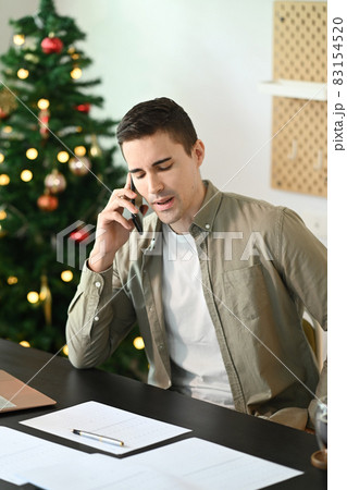 Young man entrepreneur siting in home office and talking on mobile phone. 83154520