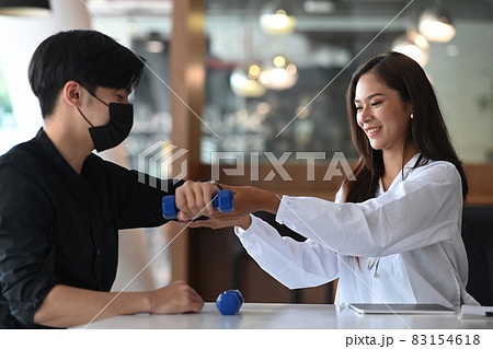 Female Physiotherapist working examining treating injured arm of male patient. 83154618