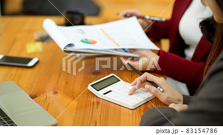 Two of businesswomen reading financial document, working and communicating 83154786