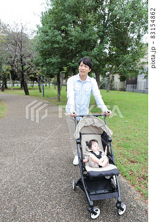 0歳の赤ちゃんとベビーカーで散歩するパパ 0歳の赤ちゃんとベビーカーで散歩するパパ 83154862