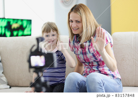 Mom and daughter record video greeting on camera Mom and daughter record video greeting on camera 83157848
