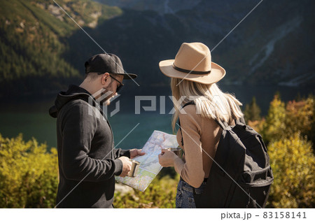Young tourist couple, man and woman, on hiking path in mountains Young tourist couple, man and woman, on hiking path in mountains 83158141