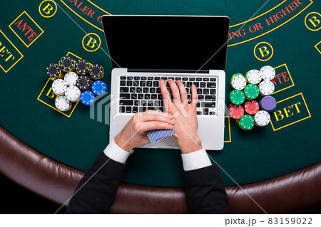 casino, online gambling, technology and people concept - close up of poker player with playing cards 83159022