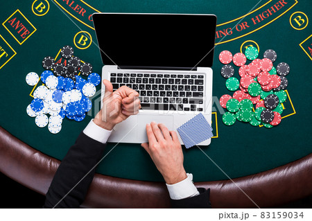 casino, online gambling, technology and people concept - close up of poker player with playing cards 83159034