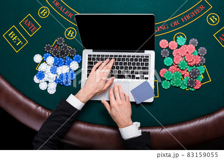 casino, online gambling, technology and people concept - close up of poker player with playing cards 83159055