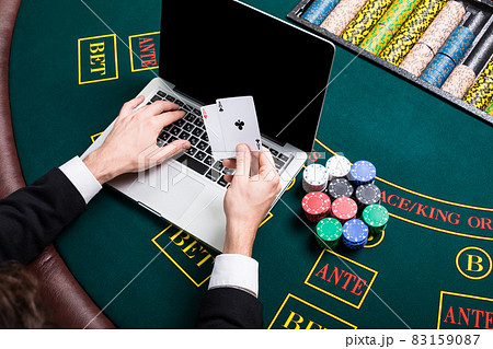 casino, online gambling, technology and people concept - close up of poker player with playing cards 83159087