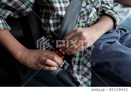 Hands of African child fastening seatbelt before riding 83159453