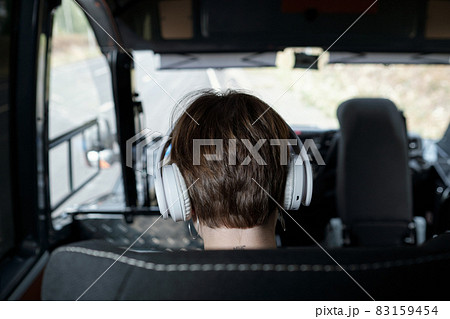 Rear view of head of girl in headphones traveling by bus Rear view of head of girl in headphones traveling by bus 83159454