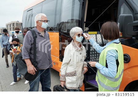 Young bus conductor checking body temperature of passengers Young bus conductor checking body temperature of passengers 83159515