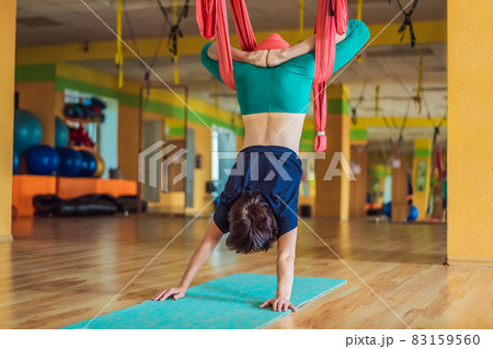 Senior mature woman practices anti-gravity yoga with a hammock in a studio. Lifestyle 83159560
