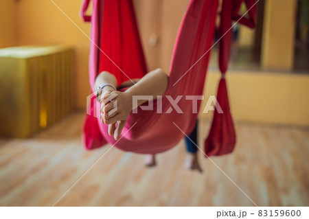 Young beautiful woman practicing aerial yoga in gym. Lifestyle 83159600