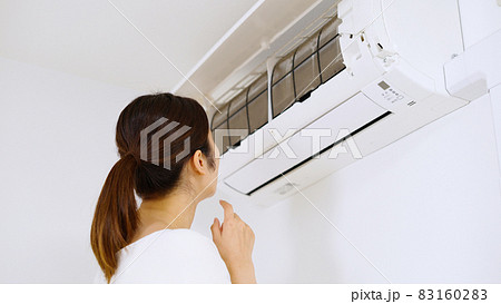 エアコンのフィルターを確認する女性. エアコンのフィルターを確認する女性. 83160283