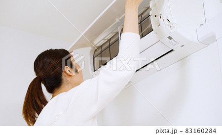 エアコンのフィルターを確認する女性. 83160284