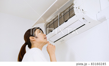 エアコンのフィルターを確認する女性. エアコンのフィルターを確認する女性. 83160285