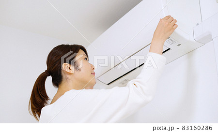 エアコンのフィルターを確認する女性. 83160286