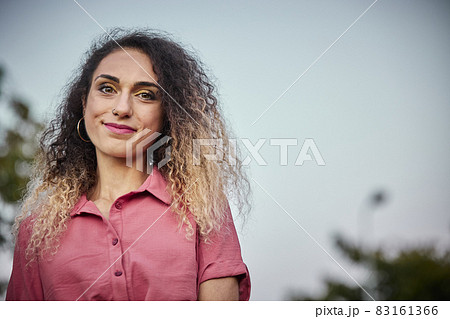 attractive blonde woman with curly hair and great copy space for ad, with a pink dress. attractive blonde woman with curly hair and great copy space for ad, with a pink dress. 83161366