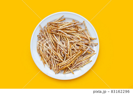 Fried taro sticks in white plate on yellow background. Fried taro sticks in white plate on yellow background. 83162296