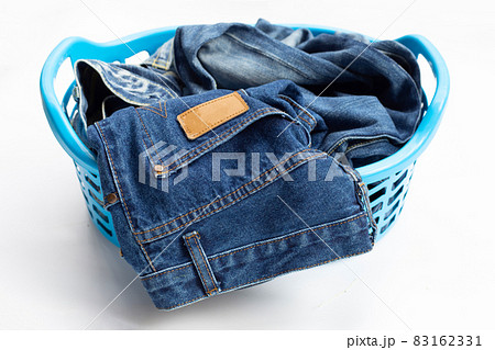 Jeans in laundry basket on white background. 83162331