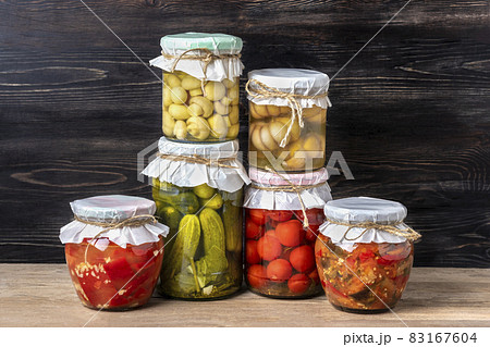 Homemade pickled cherry tomatoes, cucumbers, champignons, garlic, eggplant, red peppers in jars on wooden shelf Homemade canned and fermented foods concept Seasonal product Homemade pickled cherry tomatoes, cucumbers, champignons, garlic, eggplant, red peppers in jars on wooden shelf Homemade canned and fermented foods concept Seasonal product 83167604