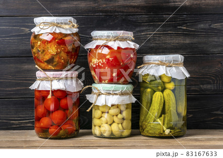 Homemade pickled cherry tomatoes, cucumbers, champignons, garlic, eggplant, red peppers in jars on wooden shelf Homemade canned and fermented foods concept Seasonal product Homemade pickled cherry tomatoes, cucumbers, champignons, garlic, eggplant, red peppers in jars on wooden shelf Homemade canned and fermented foods concept Seasonal product 83167633