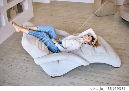 Chaise lounge in living room where woman lies. Chaise lounge in living room where woman lies. 83169381