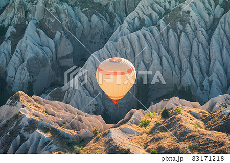 hot air balloon rising over the Cappadocian valley with chimney houses in the background hot air balloon rising over the Cappadocian valley with chimney houses in the background 83171218