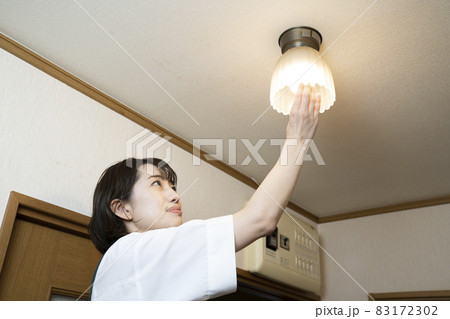 電球の交換をする家政婦の女性 電球の交換をする家政婦の女性 83172302