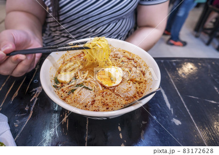 women eating pork noodle tom yum with egg on blurred wooden 83172628