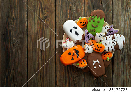 Set of ice cream and cookies with halloween character face on rustic wooden background. Halloween party background 83172723