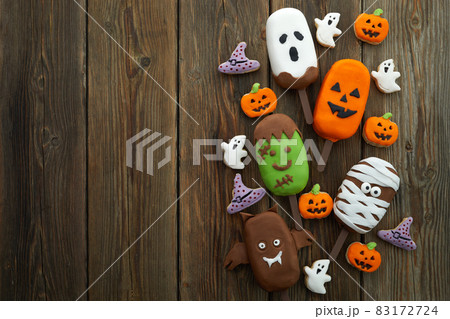 Set of ice cream and cookies with halloween character face on rustic wooden background. Halloween party background 83172724