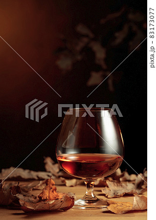 Snifter of brandy and dried-up oak leaves. Snifter of brandy and dried-up oak leaves. 83173077